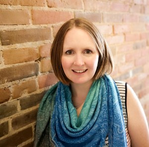 Image of Kim Callaghan, content writer, with brick wall background.